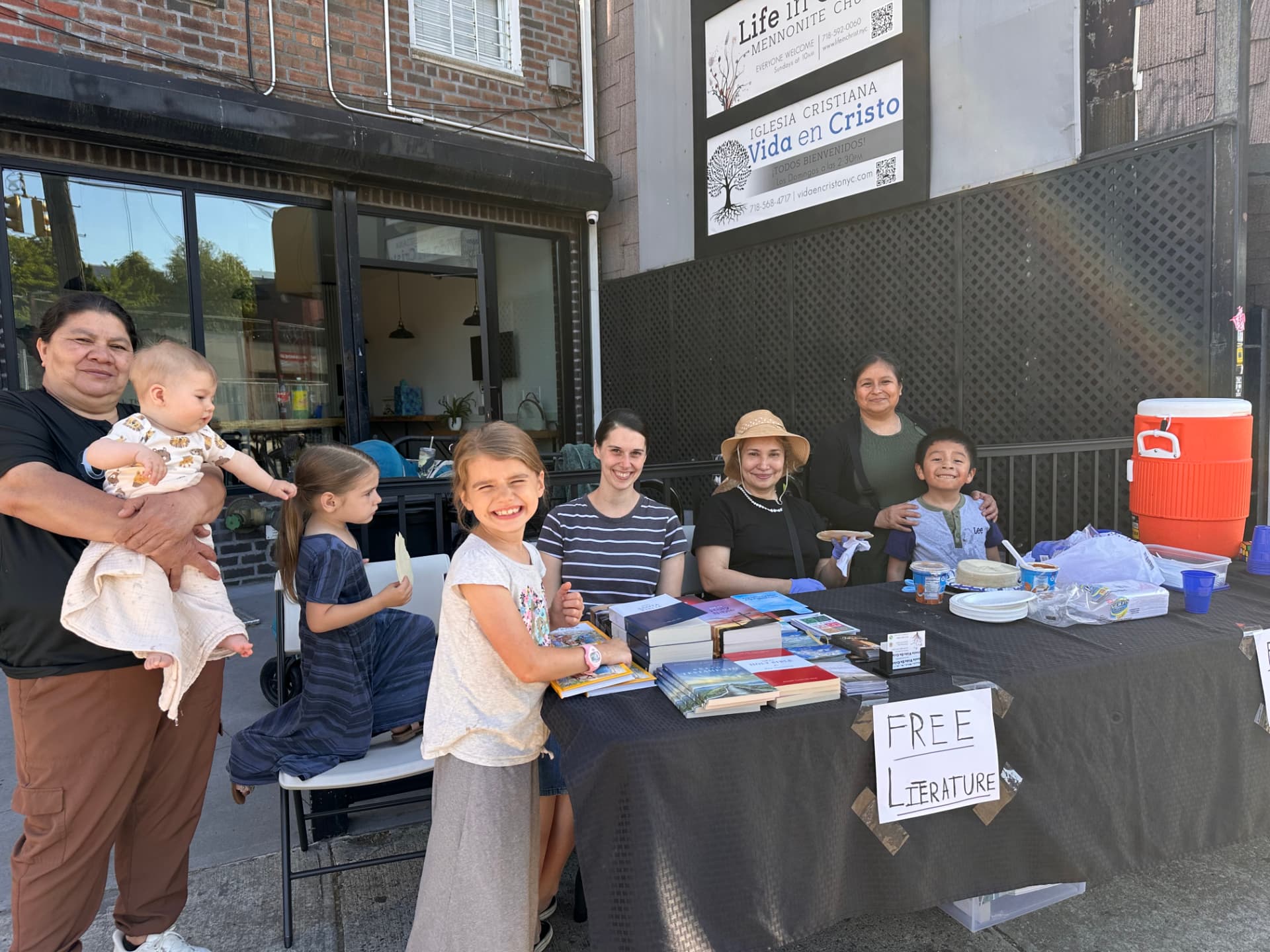 Familias de la iglesia compartiendo libros y comida con vecinos